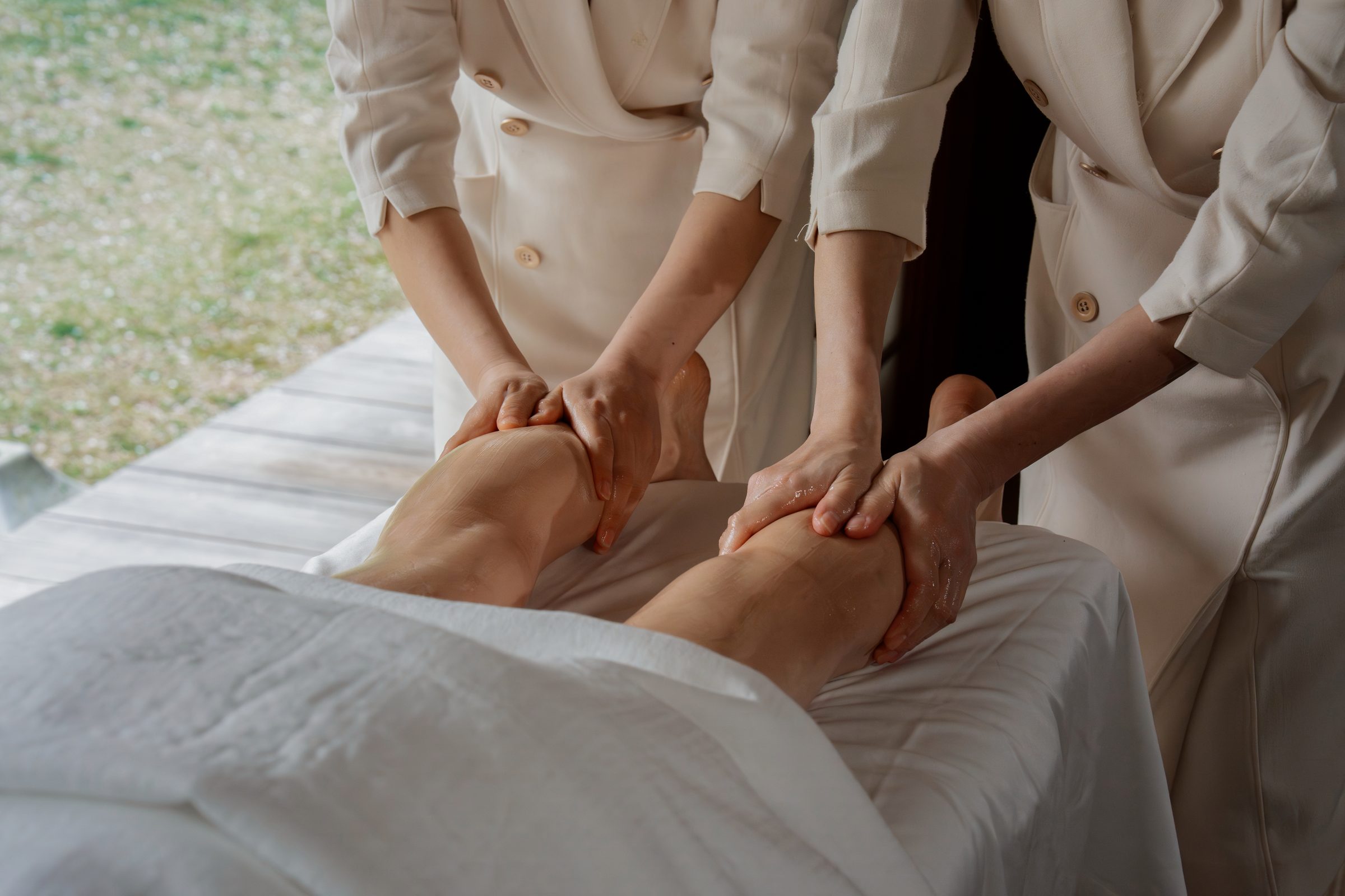 Two therapists performing leg treatment